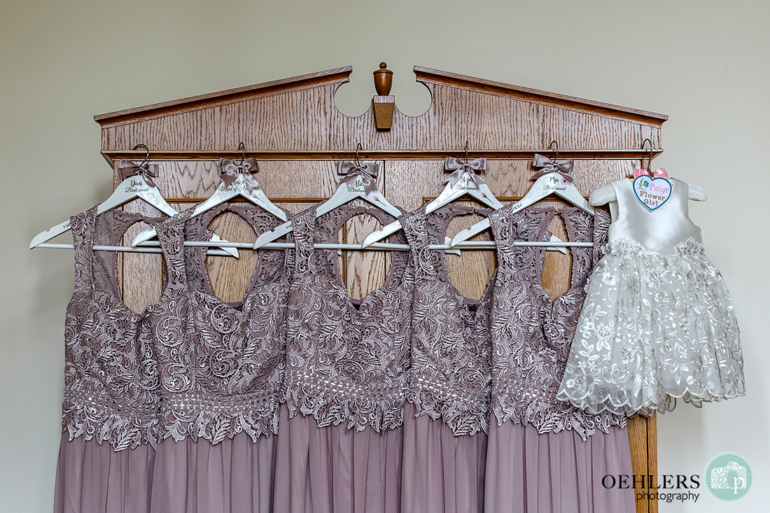 Stoke Rochford Wedding Photographer-Pastel Bridesmaids dresses and flowergirls dress hanging from a wardrobe.