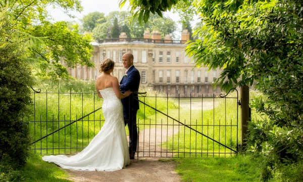 bride and groom in front of fascade of calke abbey