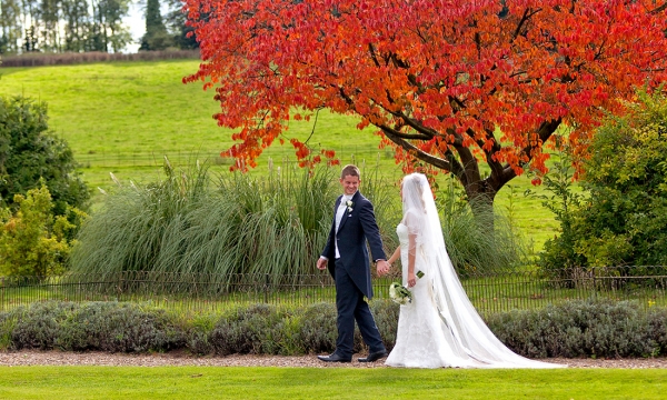 Groom and Bride walking with autumn leaves