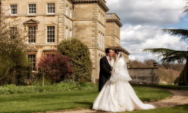 Groom and Bride kissing in front of Prestwold Hall