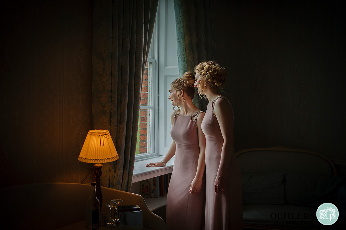 norwood park wedding preparations - beautiful window light showing two bridesmaids looking out at the view