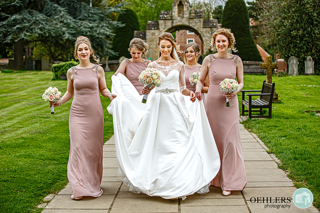 Southwell Minster wedding ceremony - the bride has arrived with her bridesmaids holding up her train