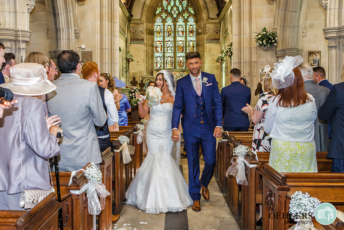 Osmaston Park wedding photography - bride and groom happily walking back up the aisle.