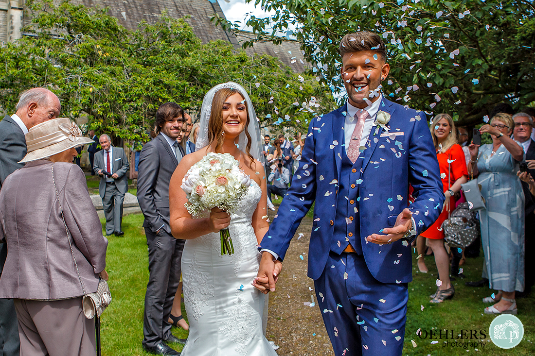 Osmaston Park wedding photography - a confetti drenched, happy couple at the end of the confetti line up.