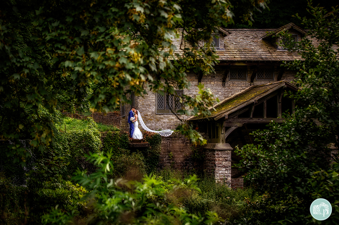 Osmaston Park wedding photography - kissing couple beside the osmaston mill