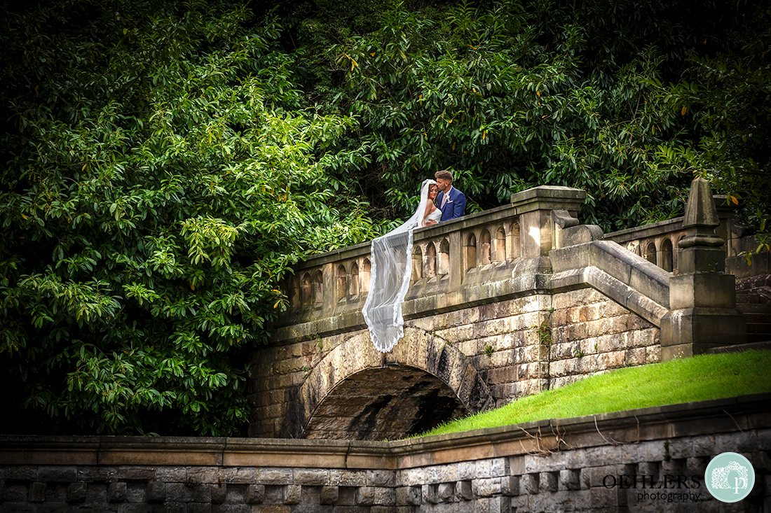 Osmaston Park wedding photography - couple on the brides with bride's veil draped over the side