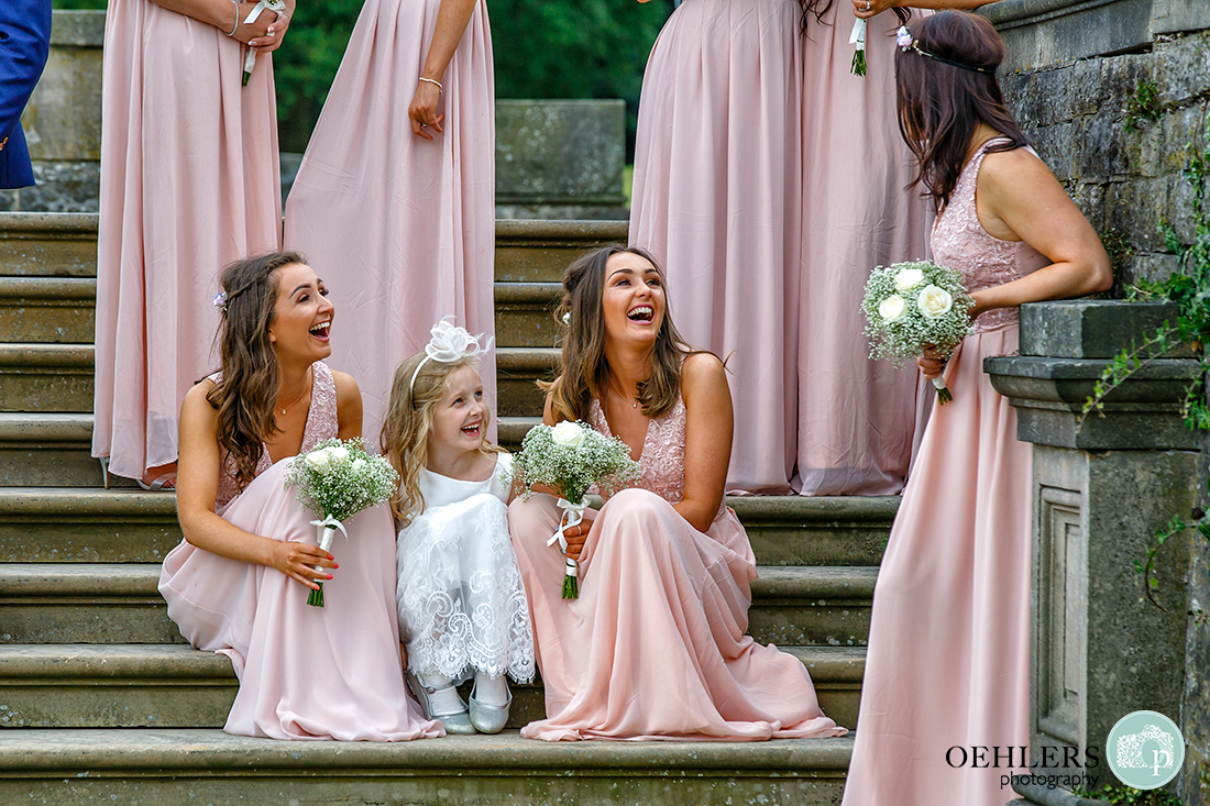 Osmaston Park wedding photography - bridesmaids and flower girl sitting on the stone steps chatting