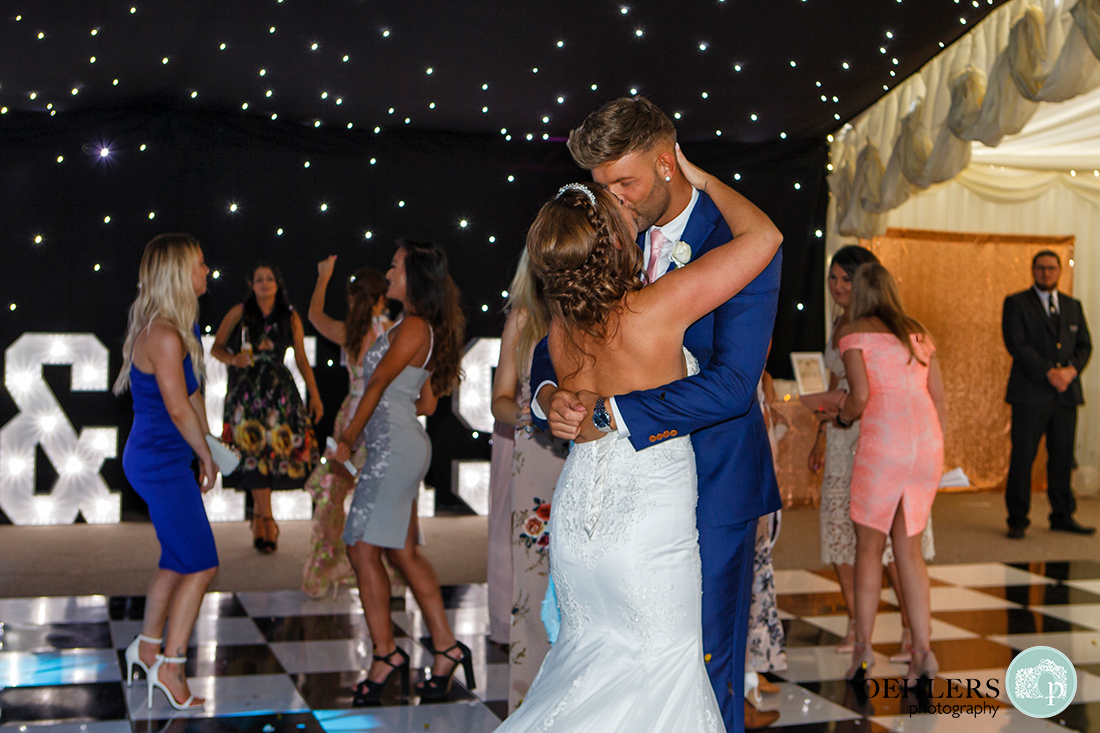 Bride and groom kissing on the dance floor