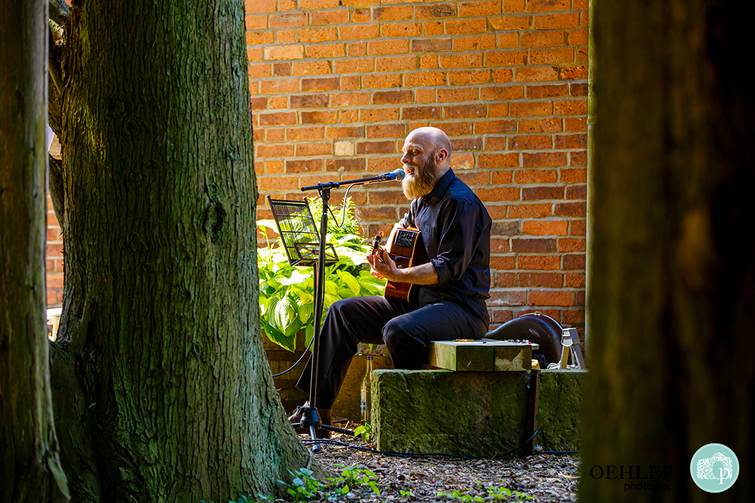A musician singing and playing the guitar in the garden
