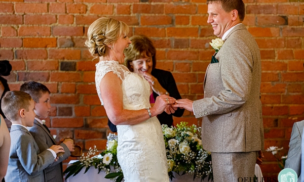Bride Laughing as she places ring on Grooms finger